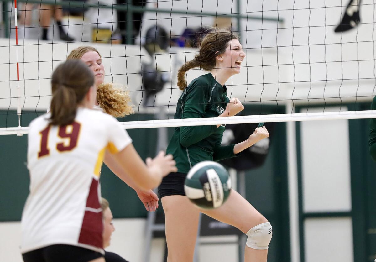 Costa Mesa's Lorelei Hobbis (12) celebrates a solo block on Estancia's Ruby Uchytil on Thursday.