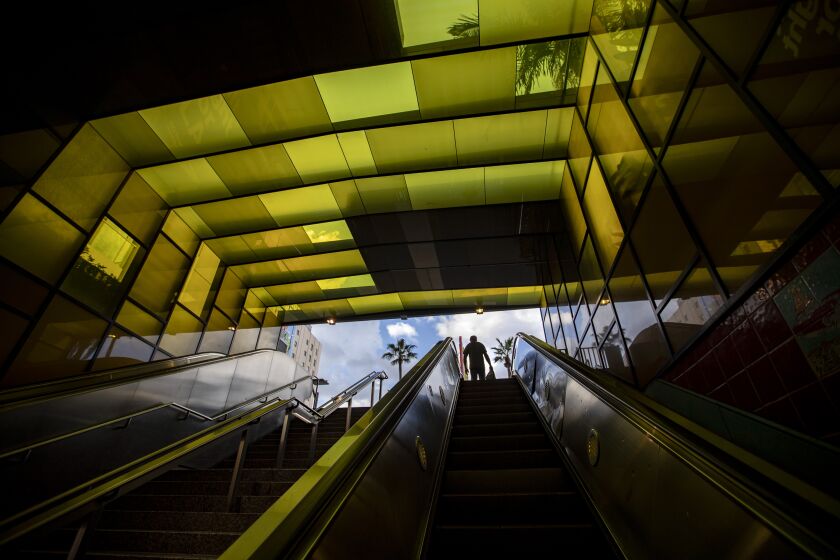 HOLLYWOOD, CALIF. -- THURSDAY, MARCH 26, 2020: A lone man rides the escalator up to Hollywood Blvd. out of the Metro Red Line's Hollywood/Vine station in Hollywood, Calif., on March 26, 2020. The coronavirus pandemic is causing ridership on LA Metro trains and busses to plummet in Los Angeles. (Brian van der Brug / Los Angeles Times)
