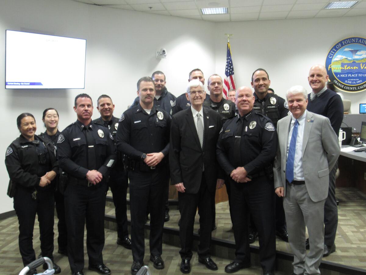 Tom Borgquist, a retiring Fountain Valley police chaplain, stand with police department members.