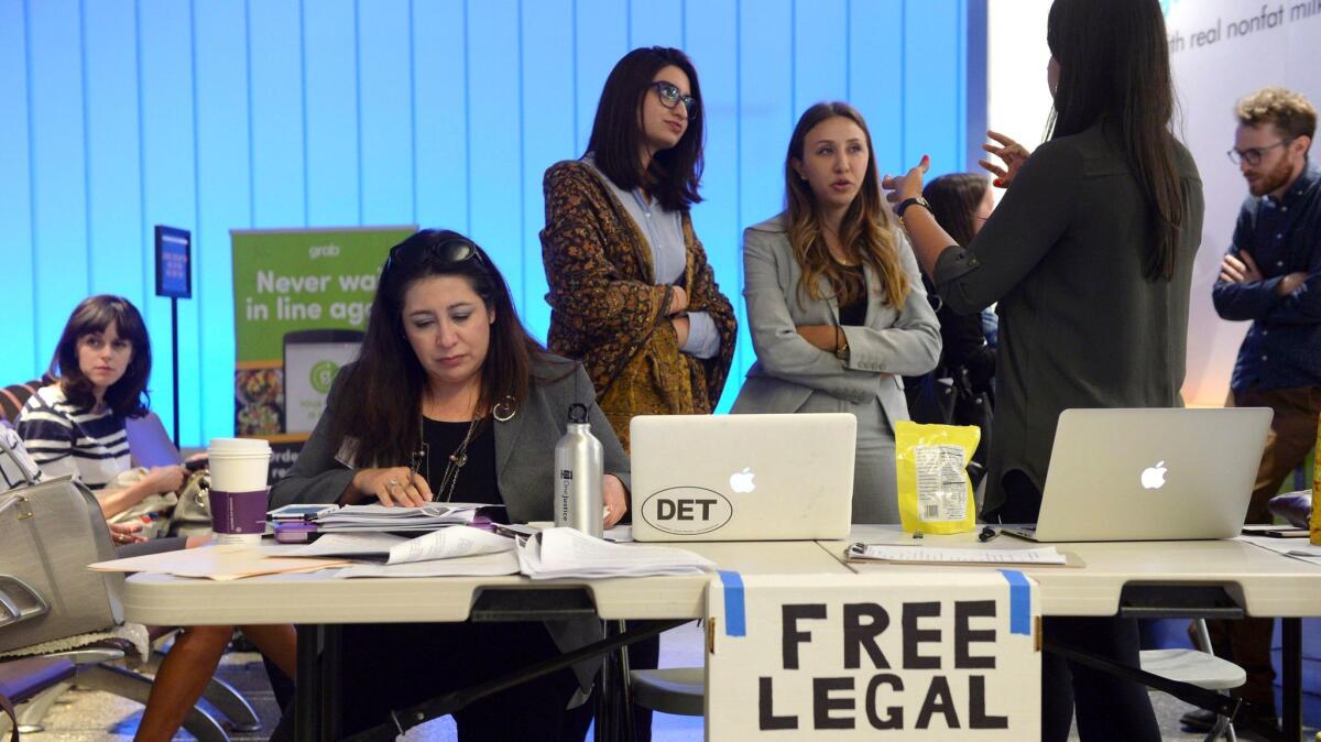 Immigration attorneys set up a table at Los Angeles International Airport as the new travel ban went into effect on Thursday. (Stephen Carr / AP)