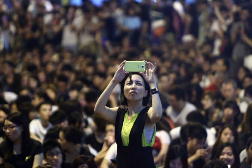 A demonstrator takes a photograph during a protest outside the Central Government Offices in Hong Kong on Oct. 4.