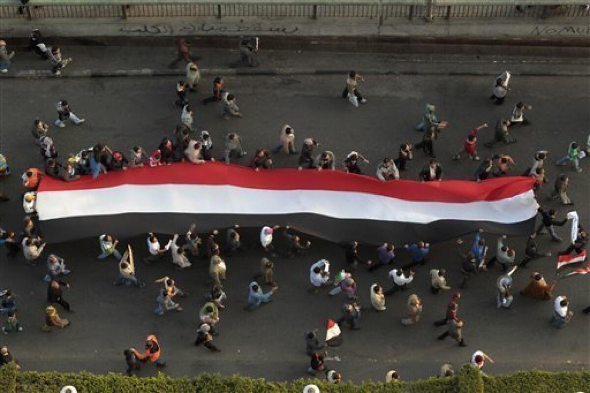Demonstrators carry a huge flag in Tahrir, or Liberation, Square in Cairo, Egypt, Tuesday, Feb. 1, 2011. More than a quarter-million people flooded into the heart of Cairo Tuesday, filling the city's main square in by far the largest demonstration in a week of unceasing demands for President Hosni Mubarak to leave after nearly 30 years in power. (AP Photo/Lefteris Pitarakis)