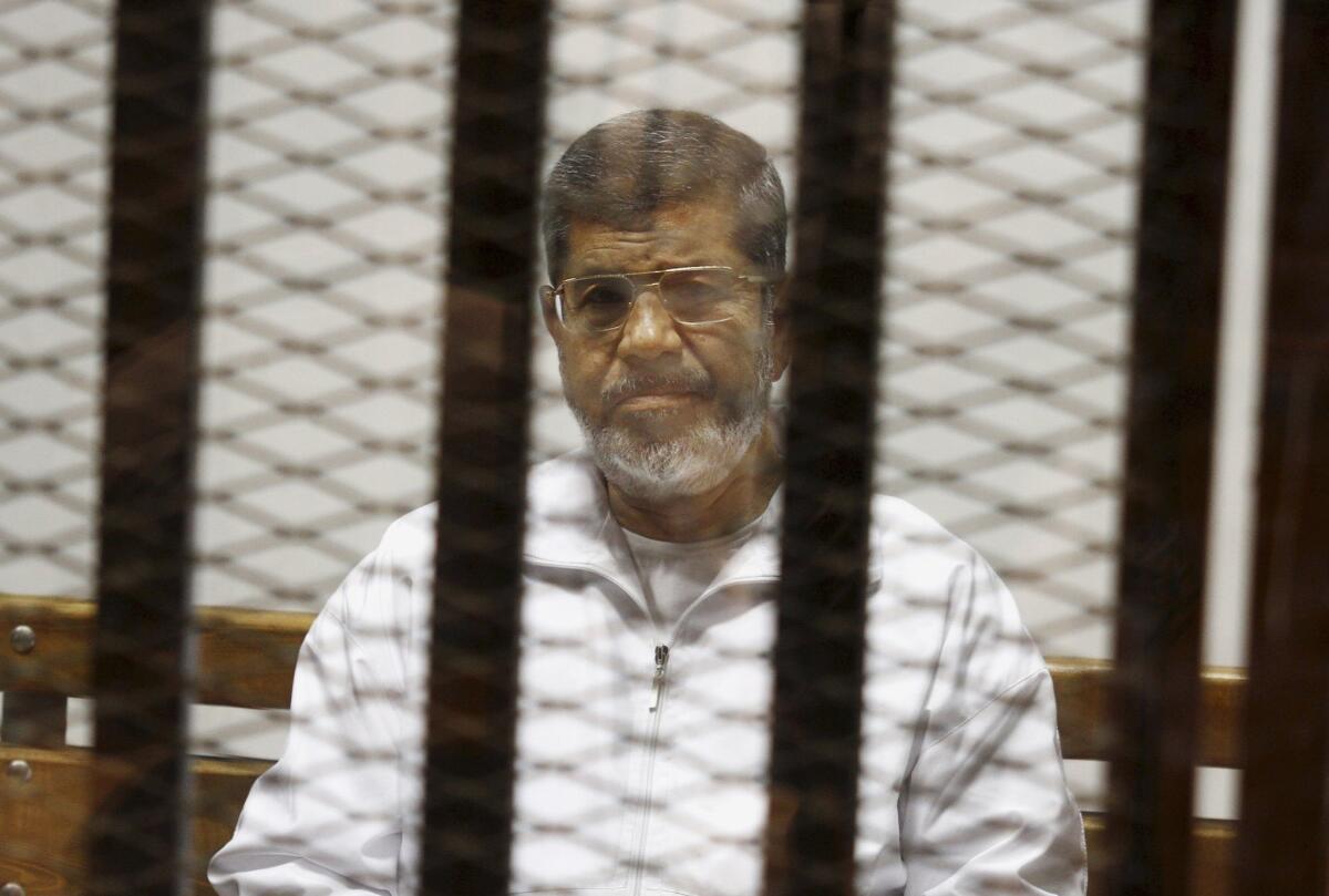 Mohamed Morsi sits in a defendant cage in the Police Academy courthouse in Cairo on May 8, 2014.