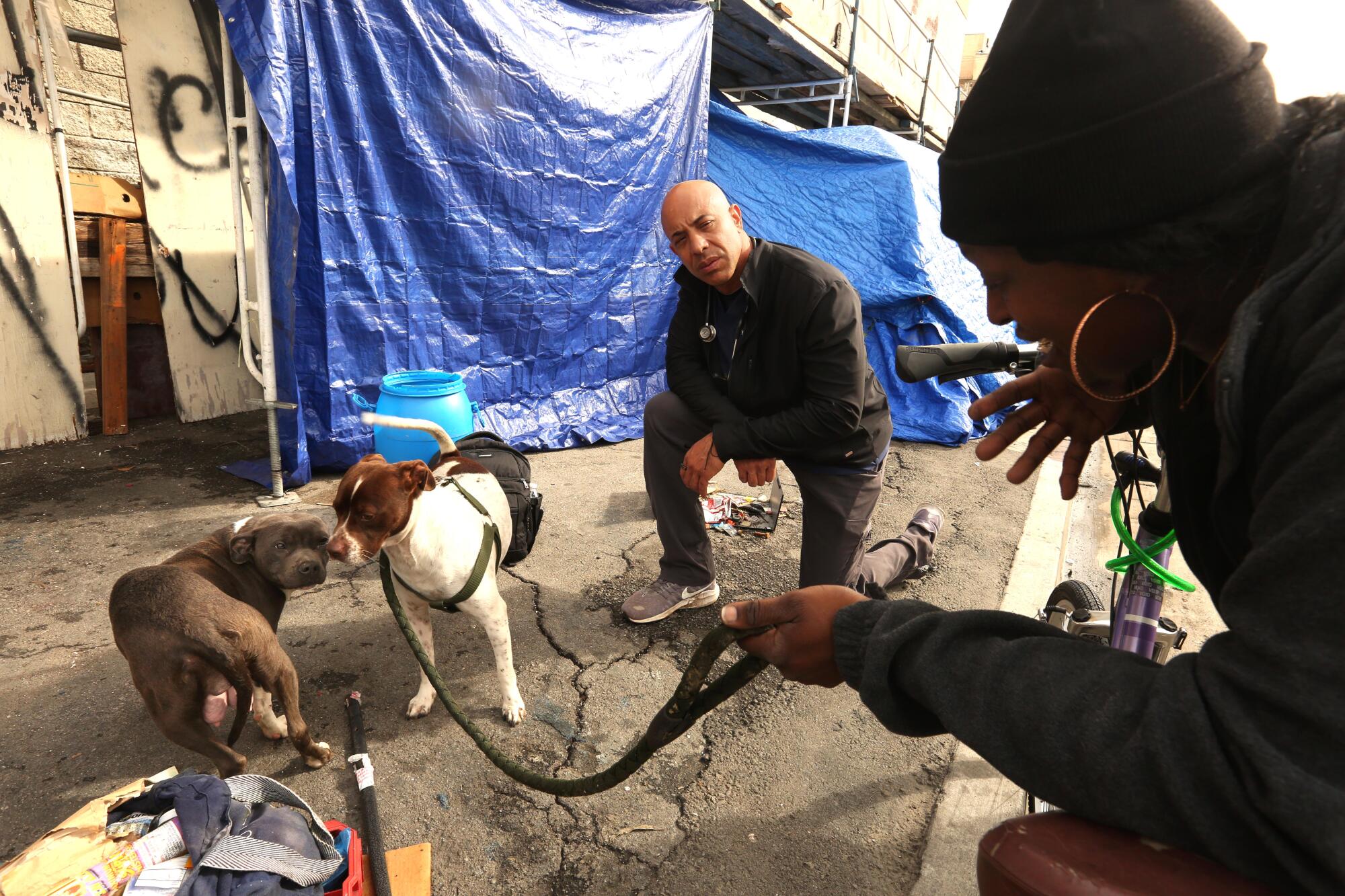 A veterinarian talks with a homeless woman about the health of her dog in Skid Row.