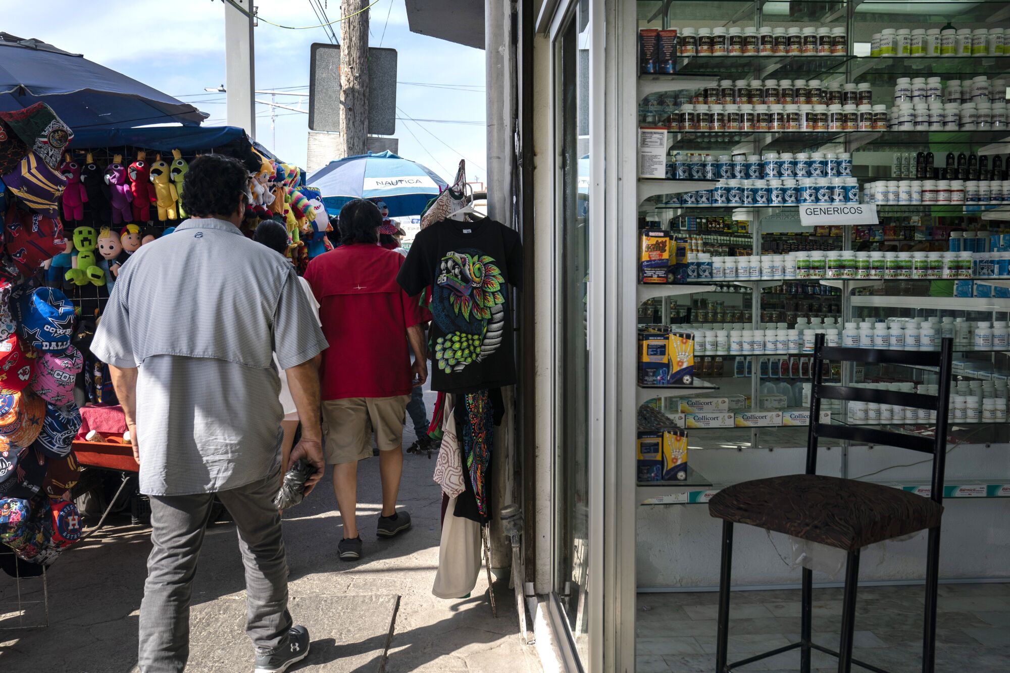 Pedestrian pass by a pharmacy in Nuevo Progreso, Mexico.