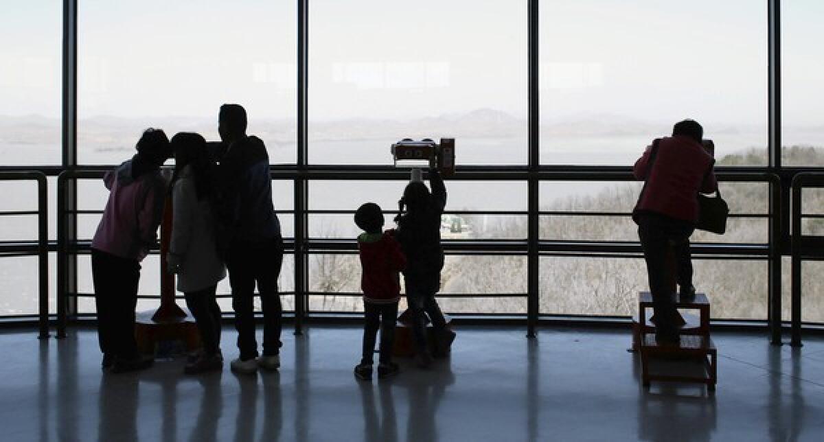 A family looks at North Korean territory from an observation post near the border village of Panmunjom, South Korea. Weeks of shrill rhetoric from North Korea, preceded by a nuclear test in February, have put U.S., South Korean and Japanese forces on high alert.