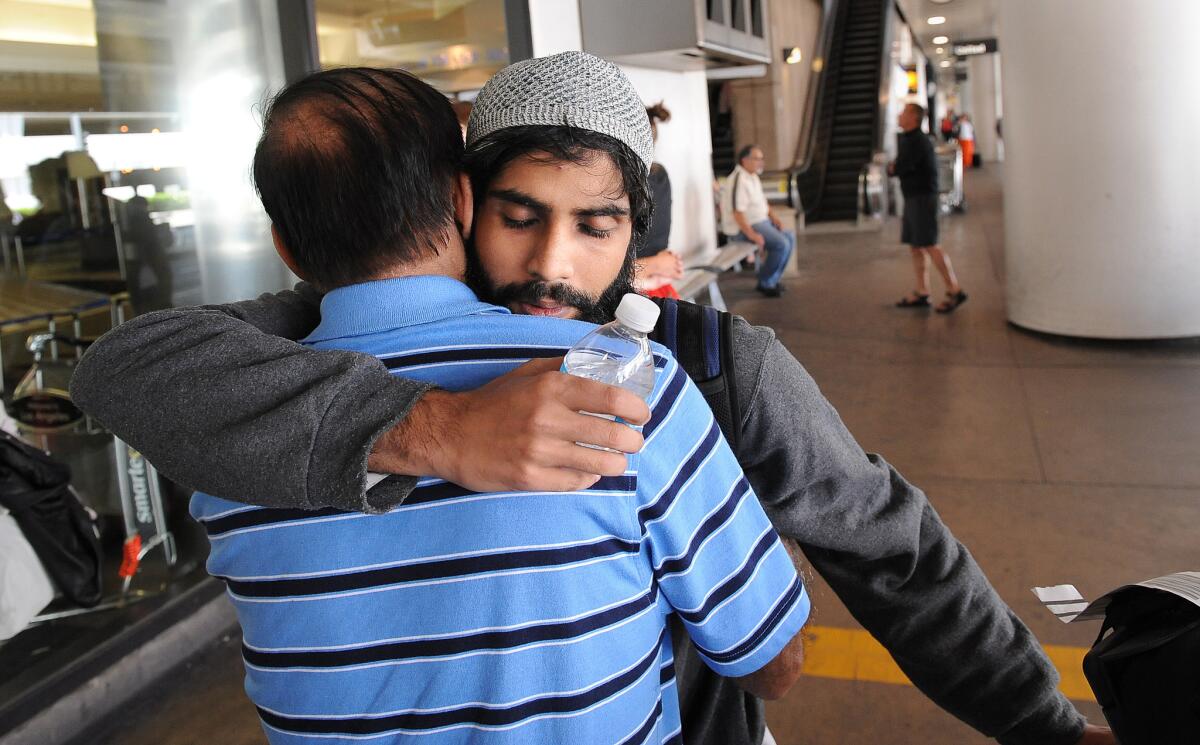 Rehan Motiwala hugs his father Rafiq after arriving at LAX.