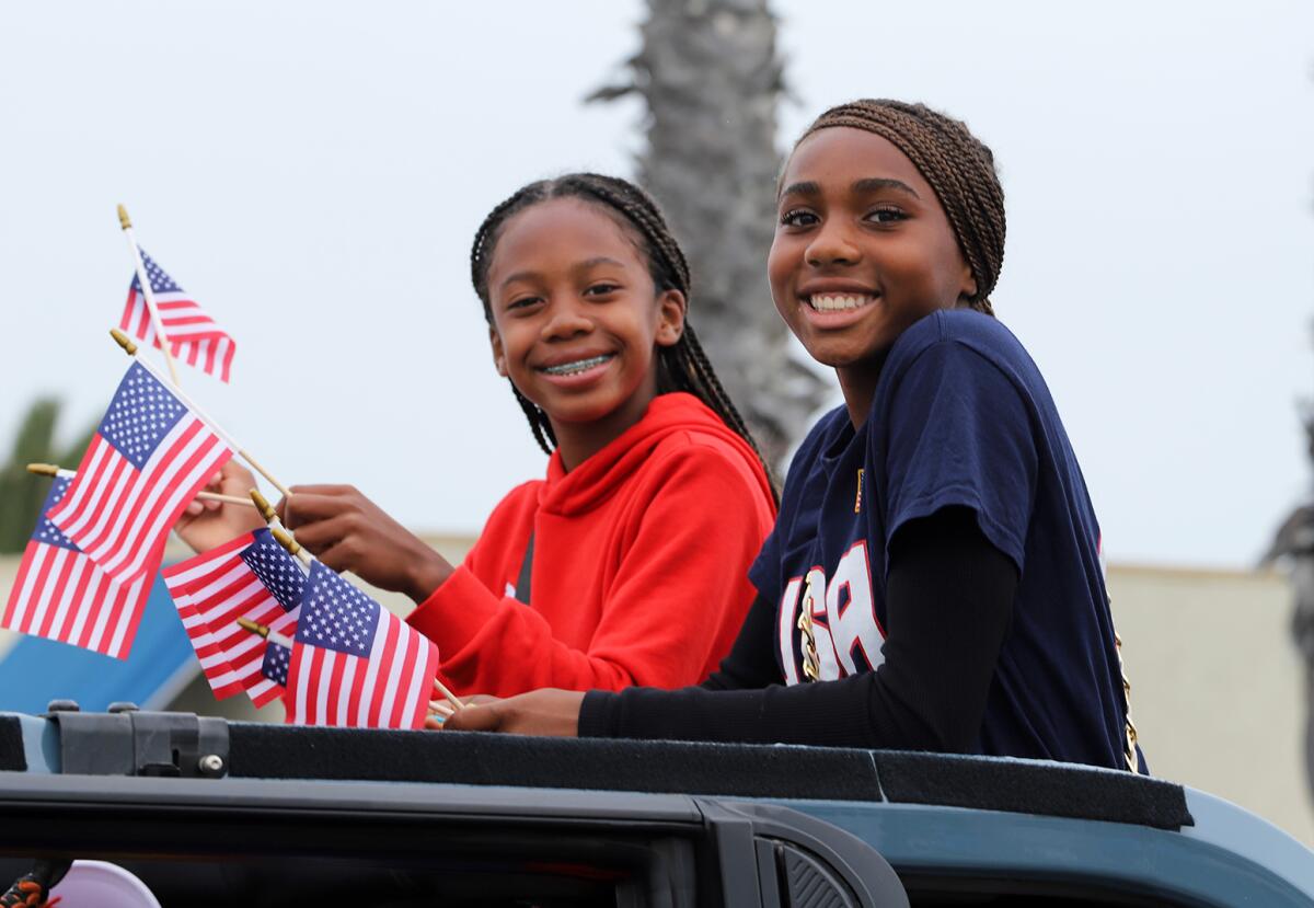 Teen Grand Marshall Fifi Garcia, left, and guest smile during the parade.