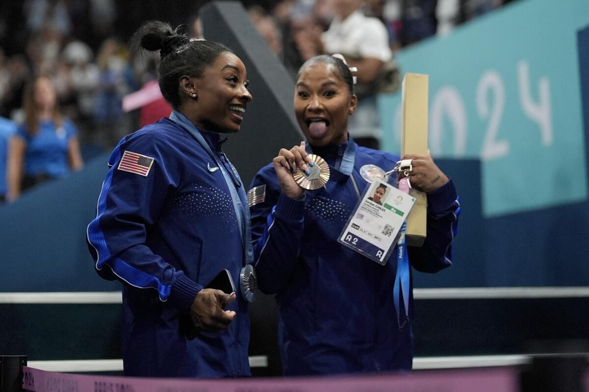 Simone Biles, left, and Jordan Chiles smile and celebrate after earning silver and bronze.