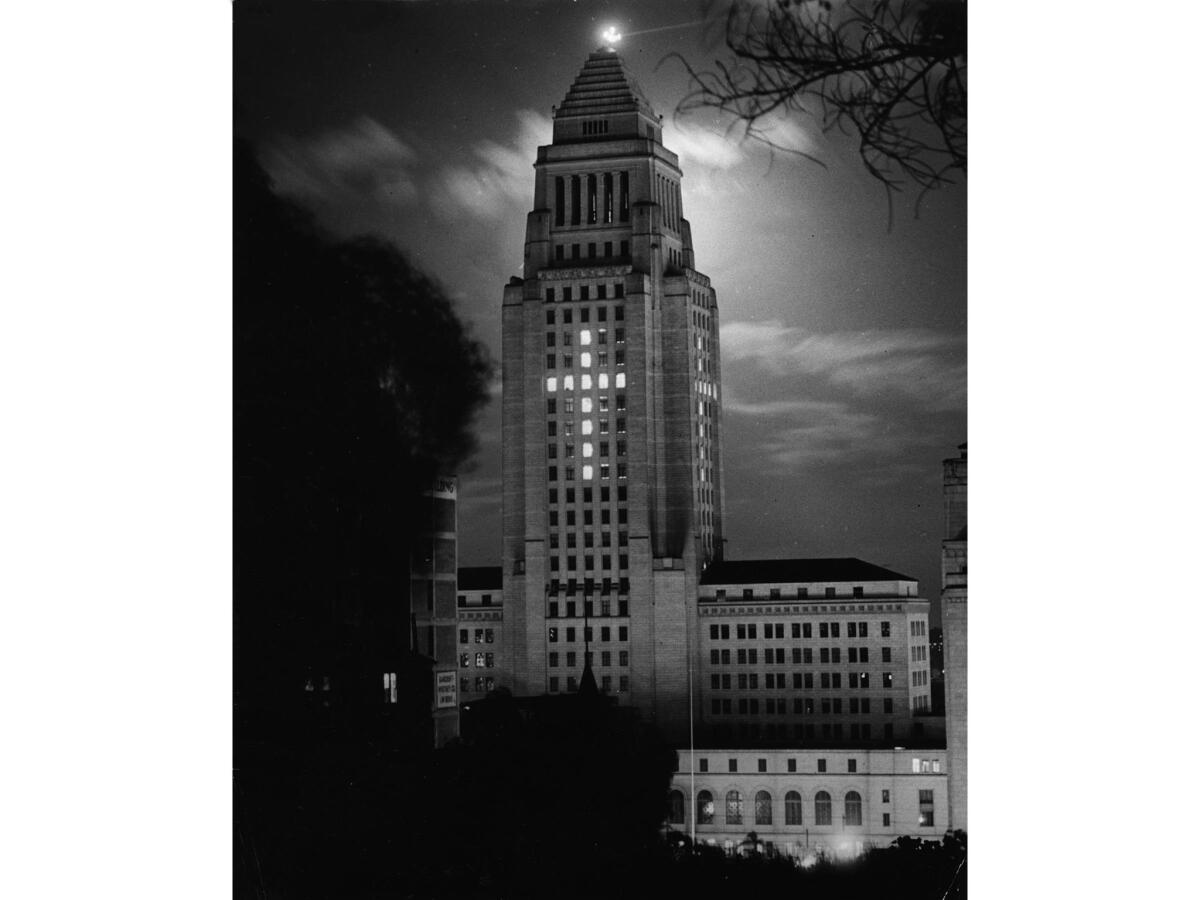 March 1937: Photo by Paul Calvert titled "Easter Morn." Los Angeles City Hall with lights on forming a cross for Easter.