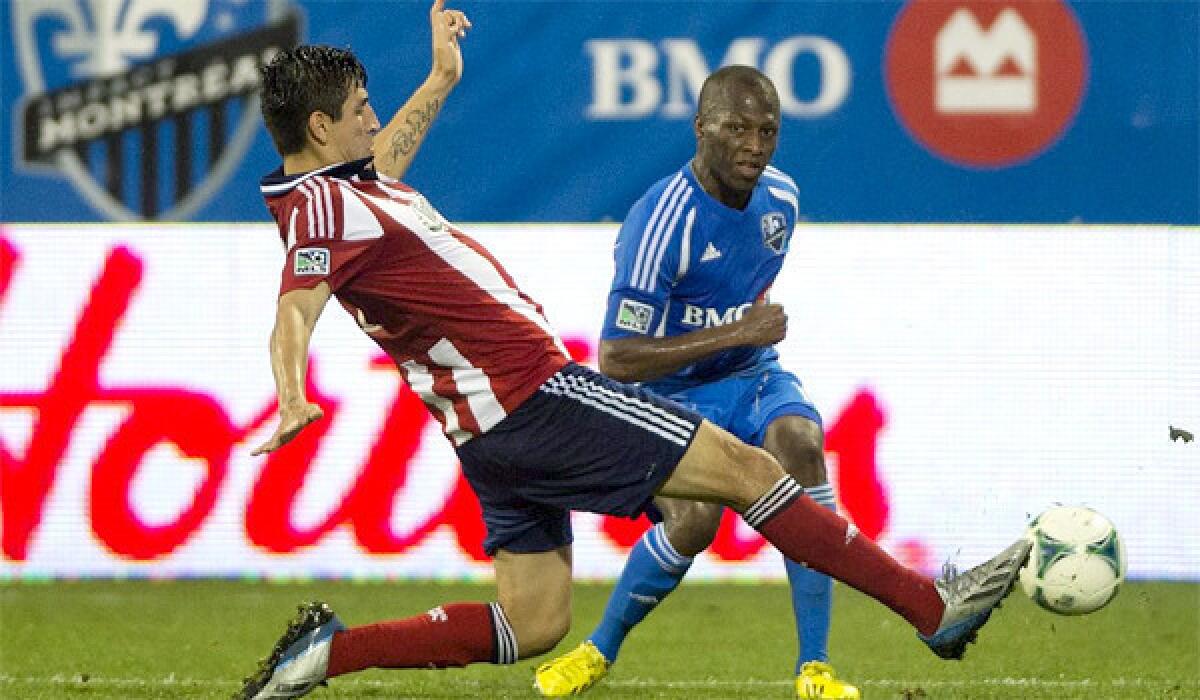 Carlos Borja challenges Sanna Nyassi for the ball during Chivas USA and the Montreal Impact's 1-1 draw on July 7, 2013.