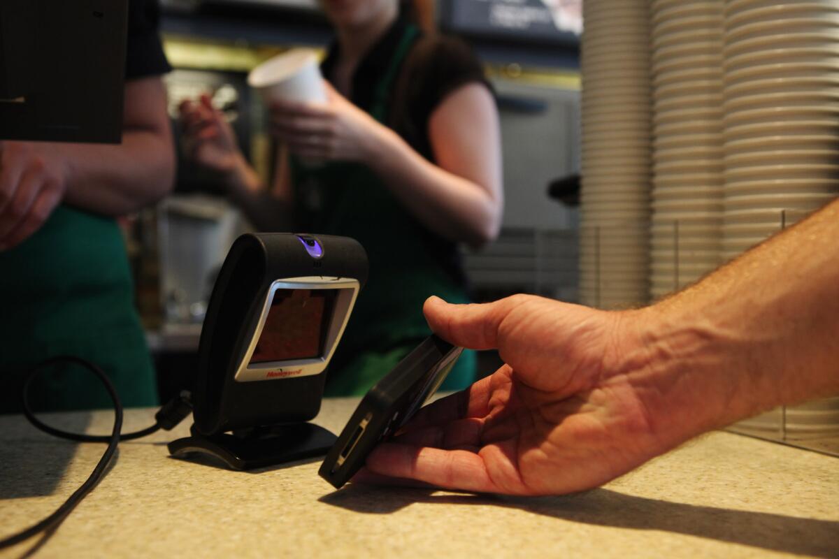 A customer uses the Starbucks iPhone app to pay for a coffee at a store in Los Angeles.