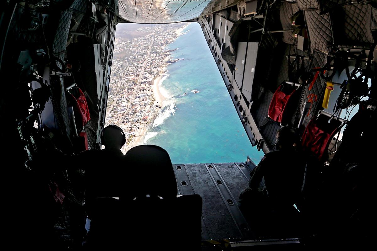 The view of the Orange County coastline through the open cargo door of a Coast Guard airplane