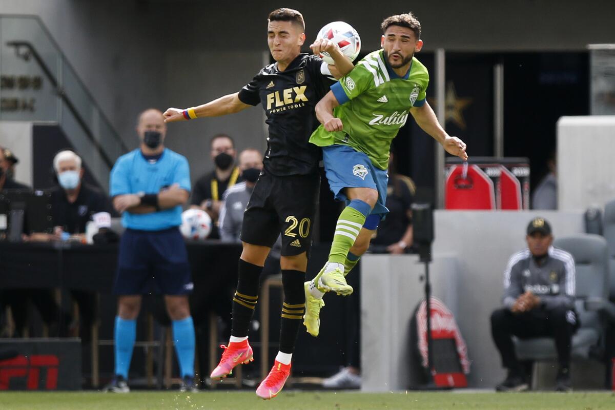 LAFC midfielder Eduard Atuesta and Seattle Sounders midfielder Cristian Roldan collide in the air going for the ball
