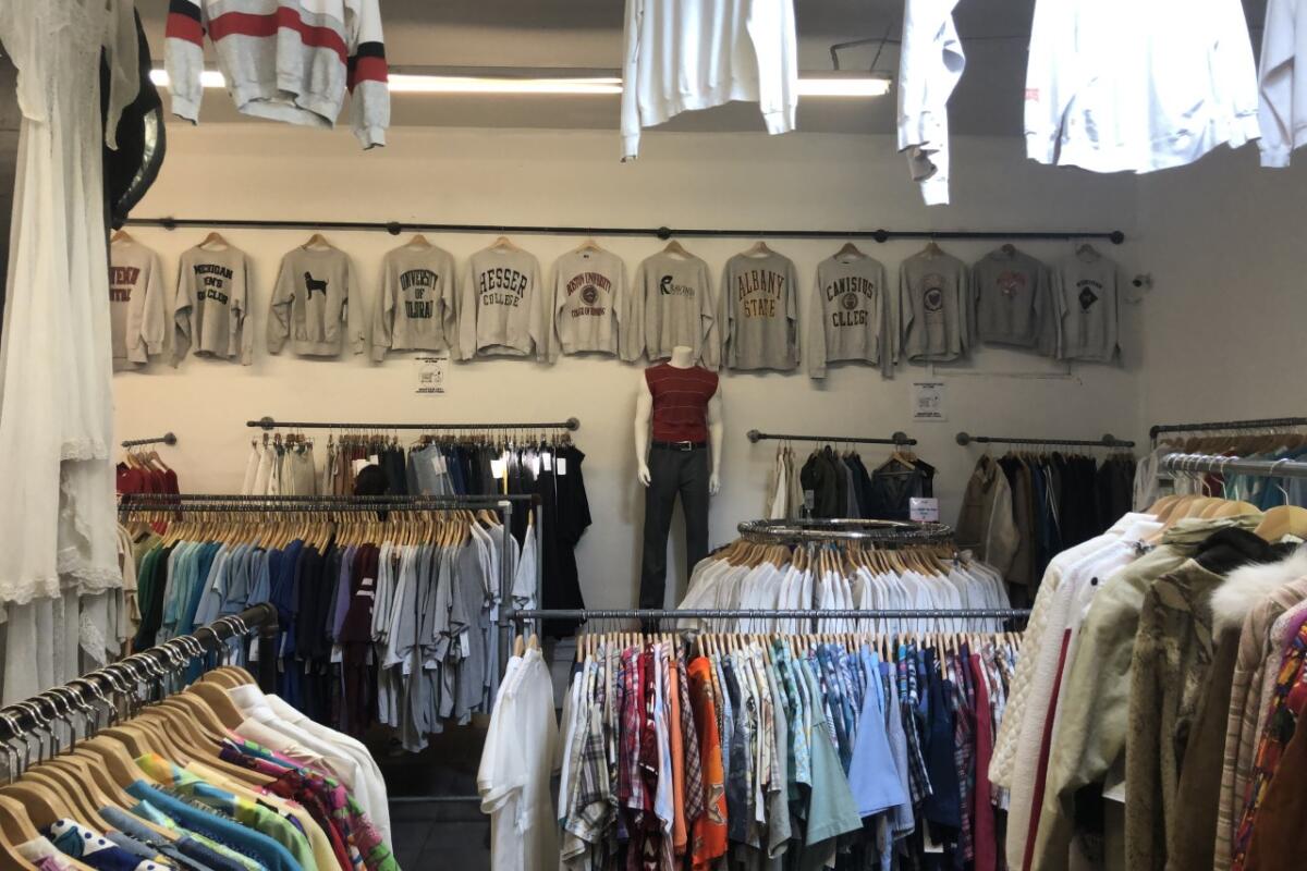 Sweatshirts, T-shirts and clothing hang on walls and display racks.