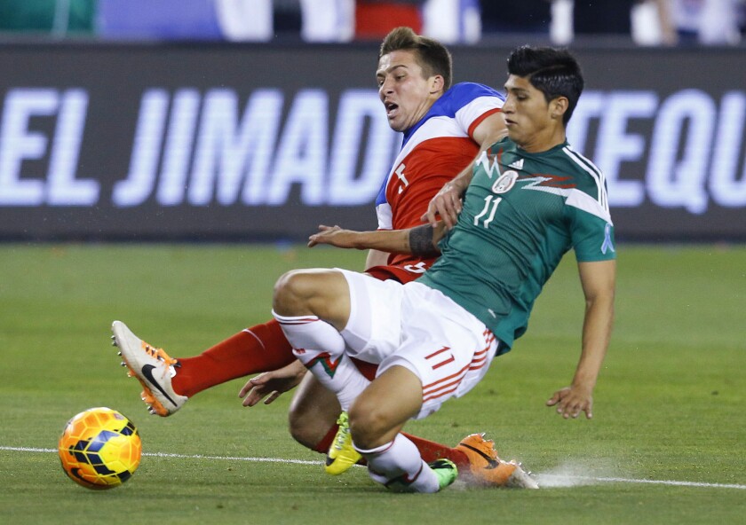 Mexico's Alan Pulido fights for the ball with Matt Besler, rear, during a soccer match in April 2014, in Glendale, Ariz. Pulido was kidnapped in Mexico's Tamaulipas state, but was rescued Sunday night.