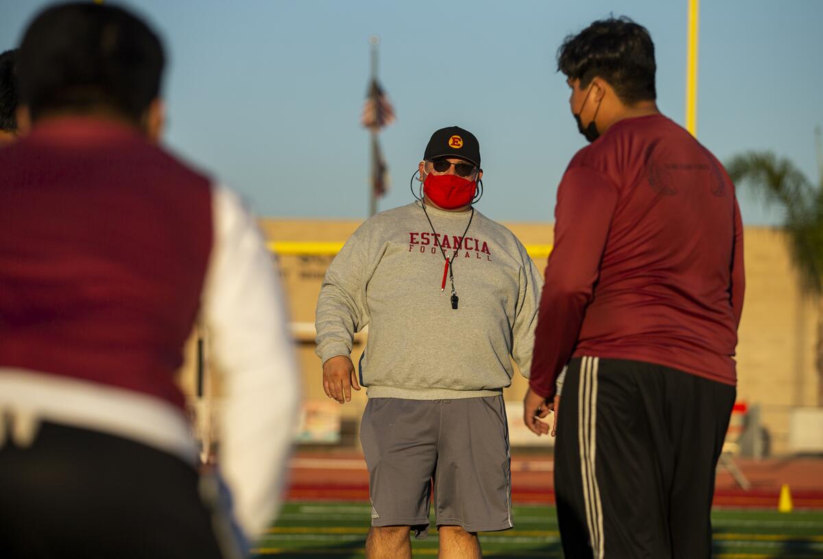 Estancia High School coach Mike Bargas works with his team during practice on Thursday.
