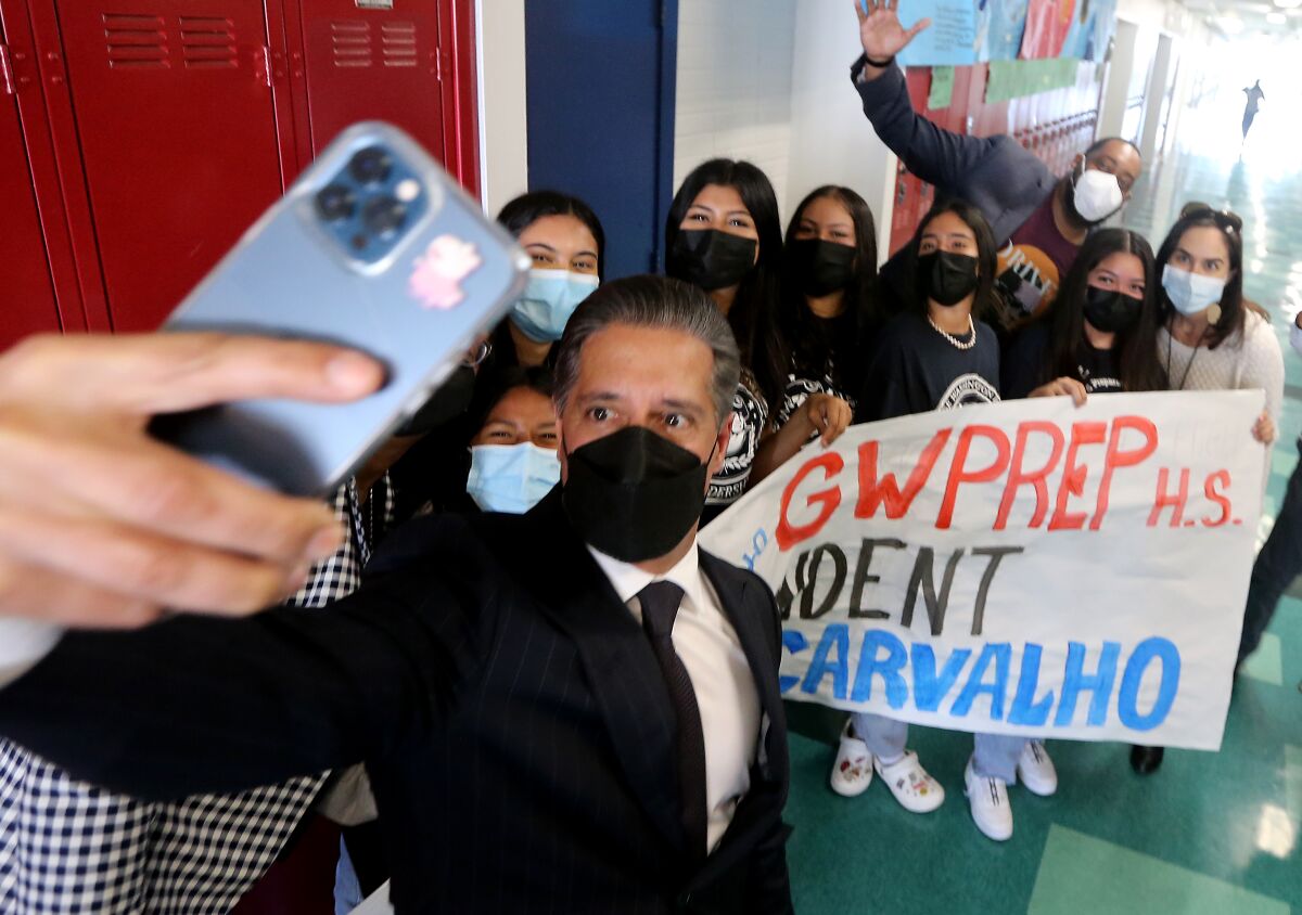 Alberto Carvalho takes a selfie with students