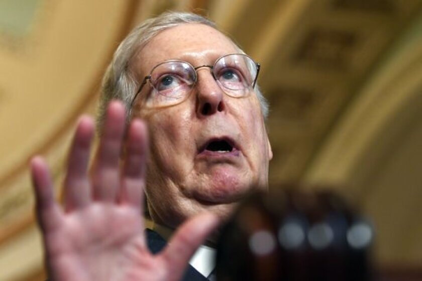 Senate Republican leader Mitch McConnell holds up a hand as he speaks