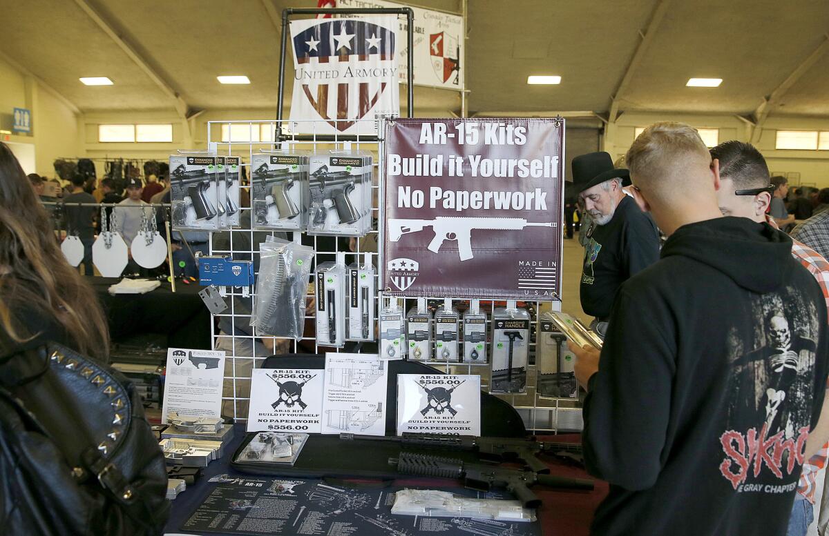 Gun enthusiasts view AR-15 semiautomatic assault rifle kits, which are legal in California, at a gun show last week in Del Mar.