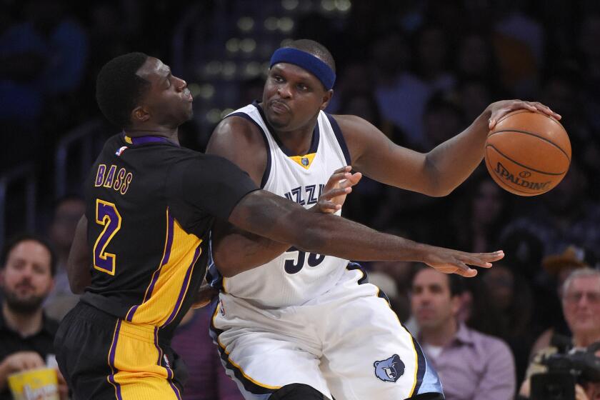 Lakers forward Brandon Bass, left, tries to knock the ball from the grasp of Grizzlies forward Zach Randolph during a game Feb. 26 at Staples Center.