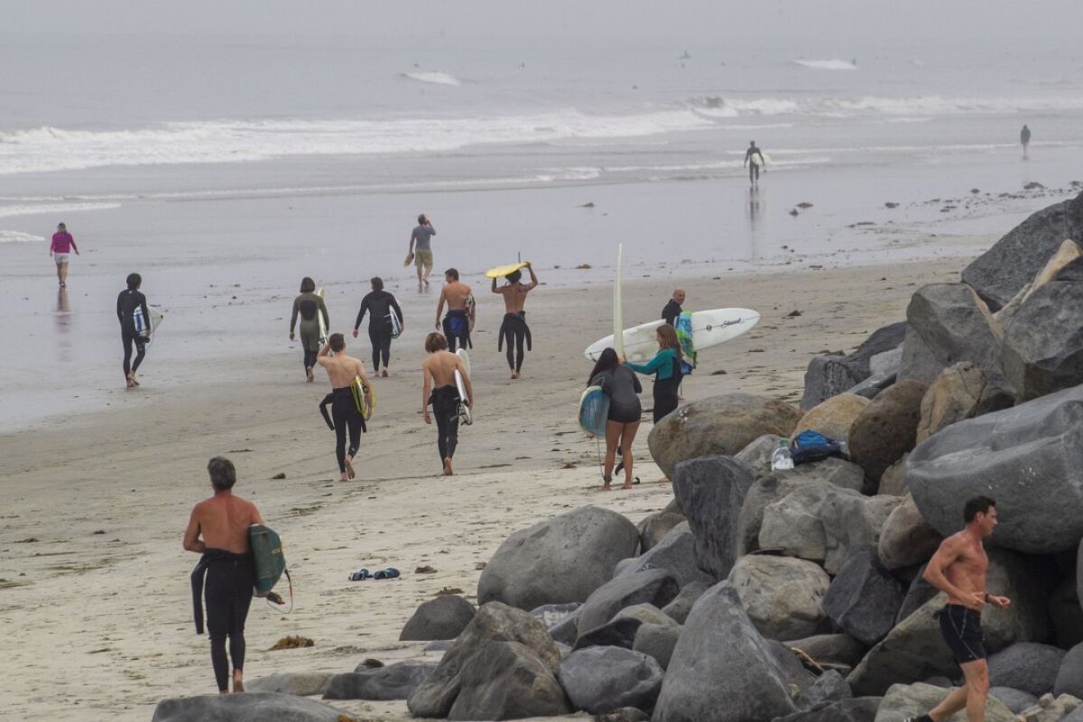 Early Monday morning on April 27, 2020 the City of Encinitas reopened its beaches in a limited manner. Surfers walked up and down the beach at low tide to get to their favorite surf spots. The city is trying to channel all beach users through the Moonlight Beach Park.