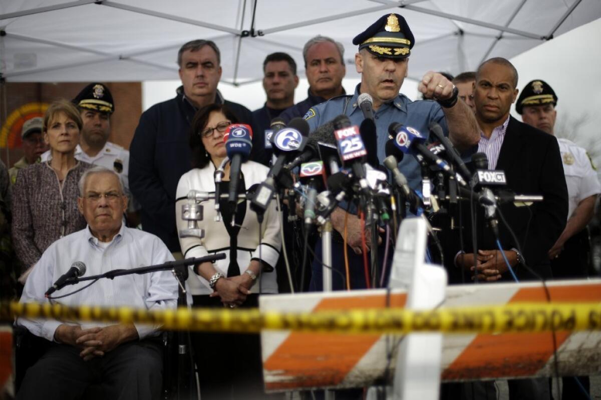 Massachusetts State Police Col. Timothy Alben, at microphones, accompanied by Gov. Deval Patrick (in sport coat) and other officials, met with the news media as Friday's manhunt dragged on in Boston.