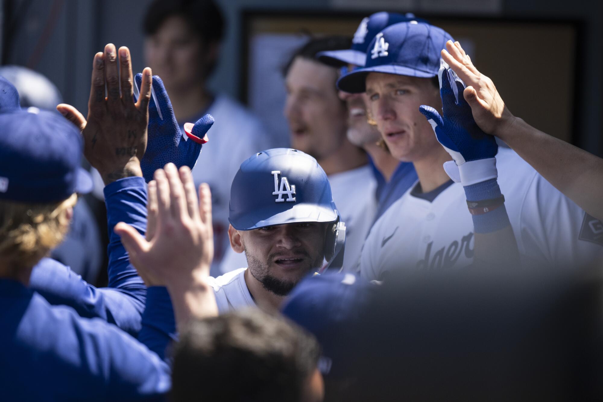 Dodgers outfielder Andy Pages is congratulated by teammates in the dugout after hitting a 3-run home run against the Mets.