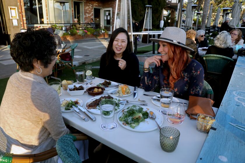 REDONDO BEACH, CA - APRIL 27: Sheryl Rasmussen, of Rancho Palos Verdes, left, Eileen Yun, of Rancho Palos Verdes, and Kristy Langus, of Palos Verdes Estates, dine along S. Catalina Ave on Tuesday, April 27, 2021 in Redondo Beach, CA. They all came out to dinner because they are all fully vaccinated. They said if they were not vaccinated they would not have come out. U.S. health officials say fully vaccinated Americans don't need to wear masks outdoors anymore unless they are in a big crowd of strangers (Associated Press). (Gary Coronado / Los Angeles Times)