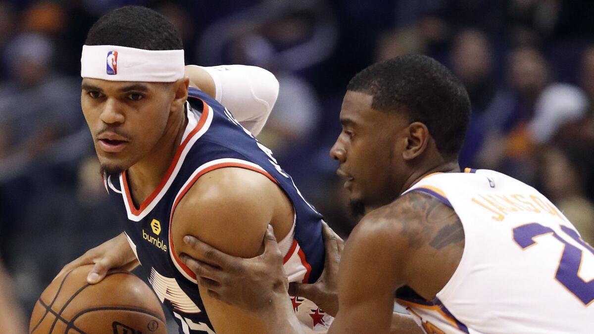 Clippers forward Tobias Harris, left, looks to pass as Phoenix Suns forward Josh Jackson defends during a game on Dec. 10.