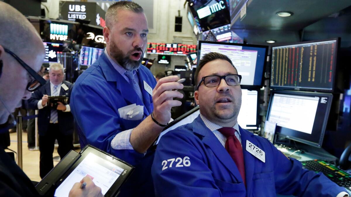 Trader Kevin Lodewick and specialist Paul Cosentino work on the floor of the New York Stock Exchange.