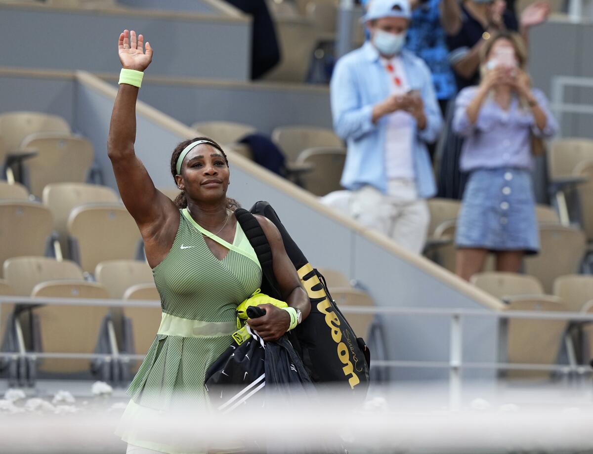 Serena Williams waves to a small crowd as she leaves court following her loss to Elena Rybakina.