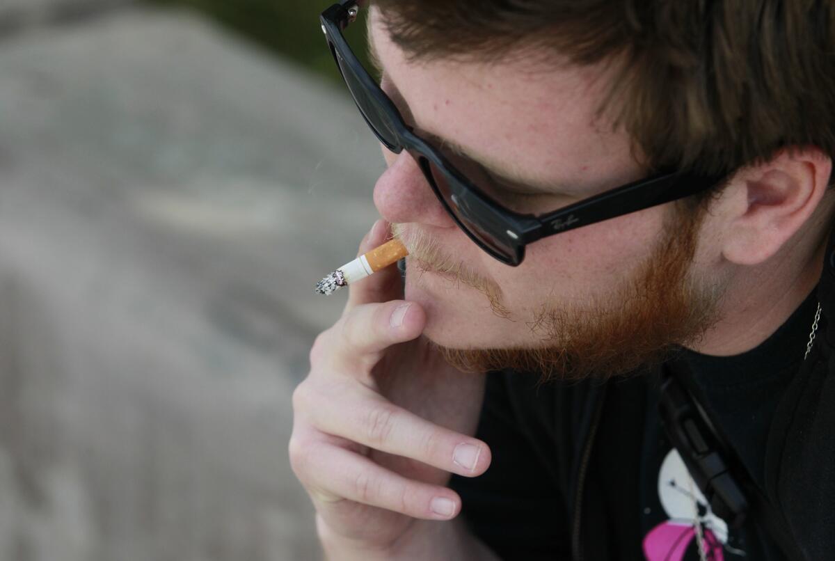 Greer Gregory, 23, has a cigarette as he waits for a friend to pick him up from OCC on Thursday.