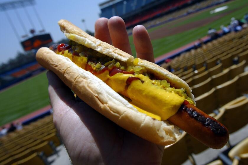 A Dodger Dog slathered in mustard, ketchup and relish at Dodger Stadium, where "it tastes really good," fans say.