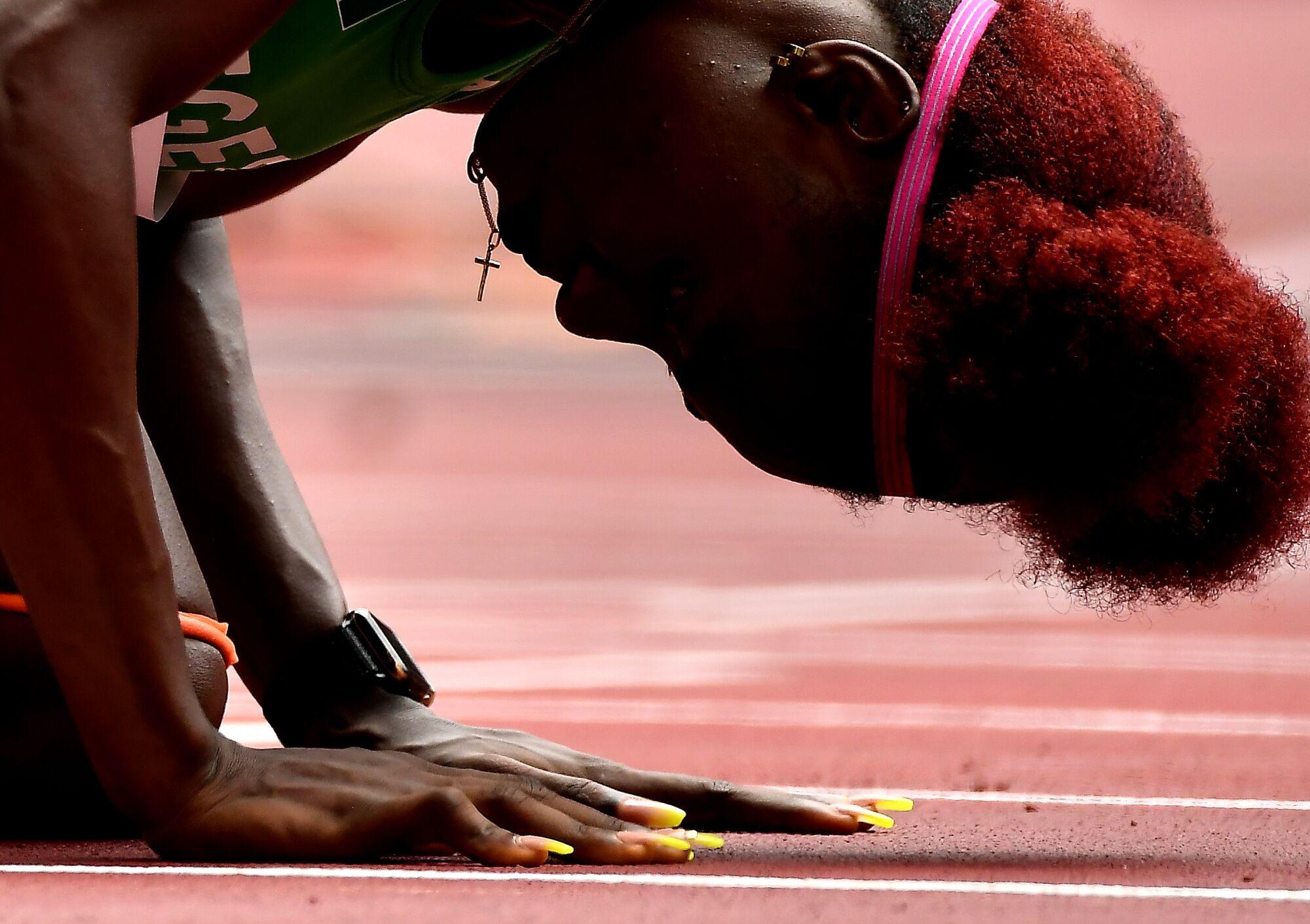 Tobi Amusan of Nigeria kneels before the women’s 100-meter hurdles at the Tokyo Olympics.