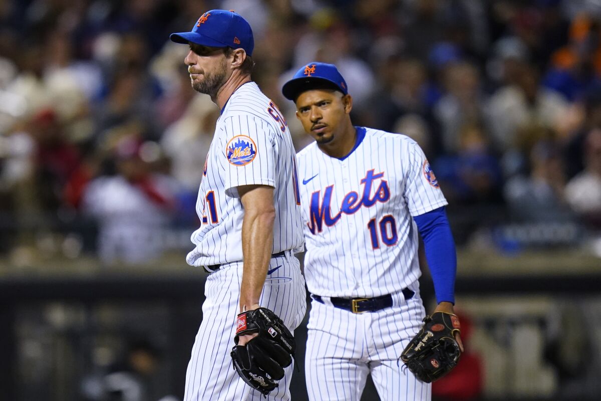 New York Mets third baseman Eduardo Escobar (10) checks on starting pitcher Max Scherzer during the sixth inning of the team's baseball game against the St. Louis Cardinals on Wednesday, May 18, 2022, in New York. (AP Photo/Frank Franklin II)
