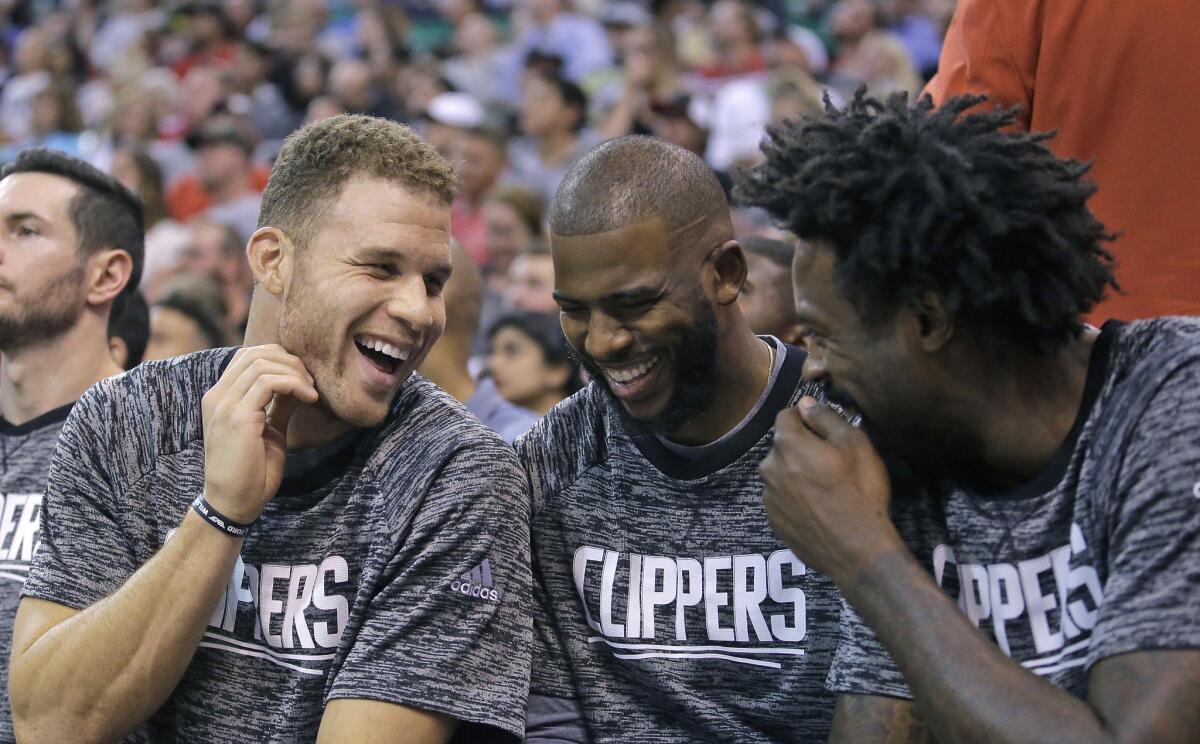 Clippers stars Blake Griffin, left, Chris Paul and DeAndre Jordan share a laugh while sitting on the bench during the second half of a preseason game against Utah on Oct. 17.
