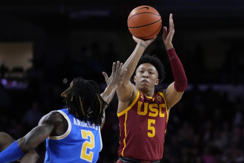 Southern California guard Boogie Ellis, right, shoots against UCLA guard Dylan Andrews.