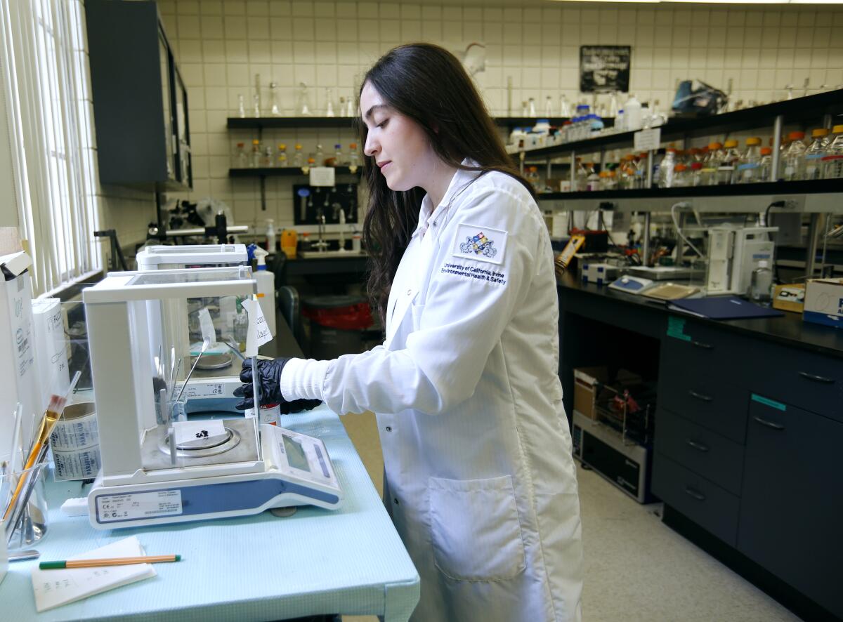 Lamees Alhassen, 26, prepares a sample at a laboratory at UCI, where she and her two siblings are doctoral students.
