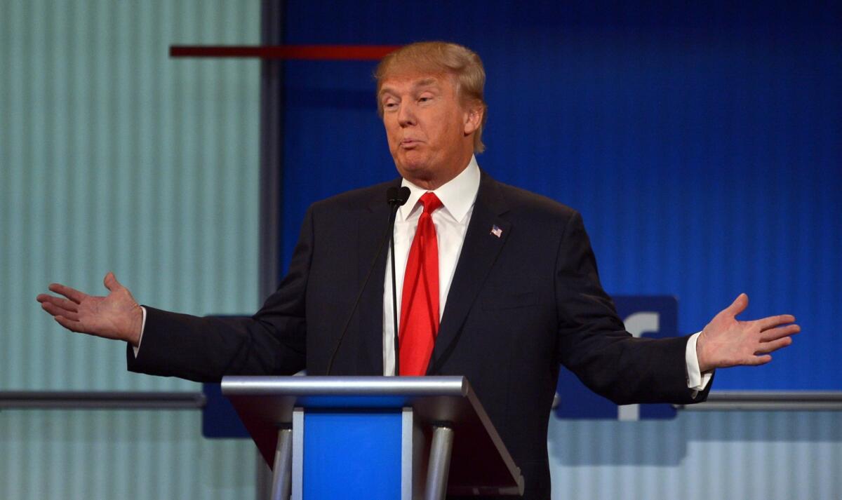 Donald Trump, positioned at center stage during the debate, responds to a question.