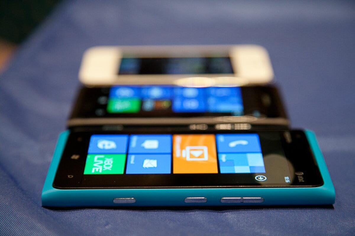 The Nokia Lumia 900 in the foreground, with the Lumia 800 in the center and the Apple iPhone 4S in the background.