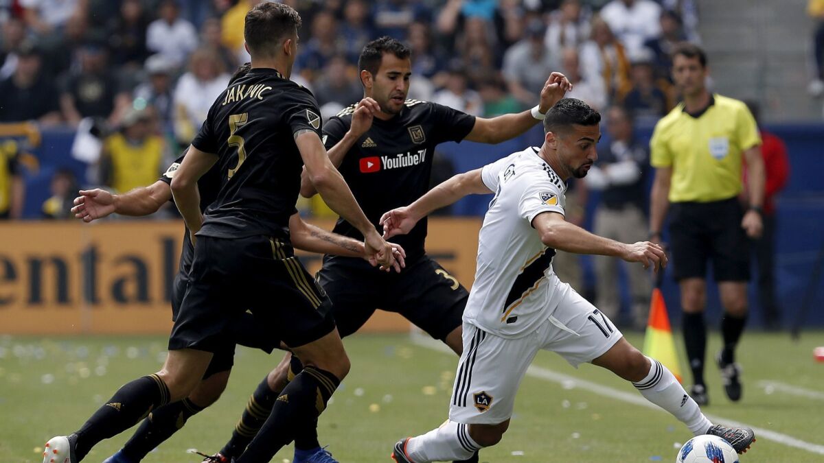 Galaxy midfielder Sebastian Lletget, right, attracts three LAFC defenders during a March 31 game at StubHub Center in Carson. The Galaxy came from behind to win 4-3.
