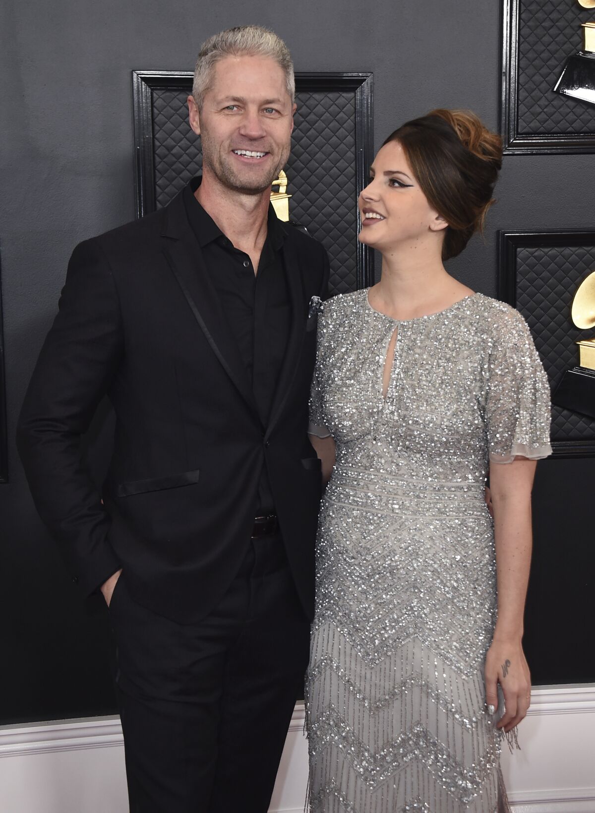A man and woman pose on a red carpet