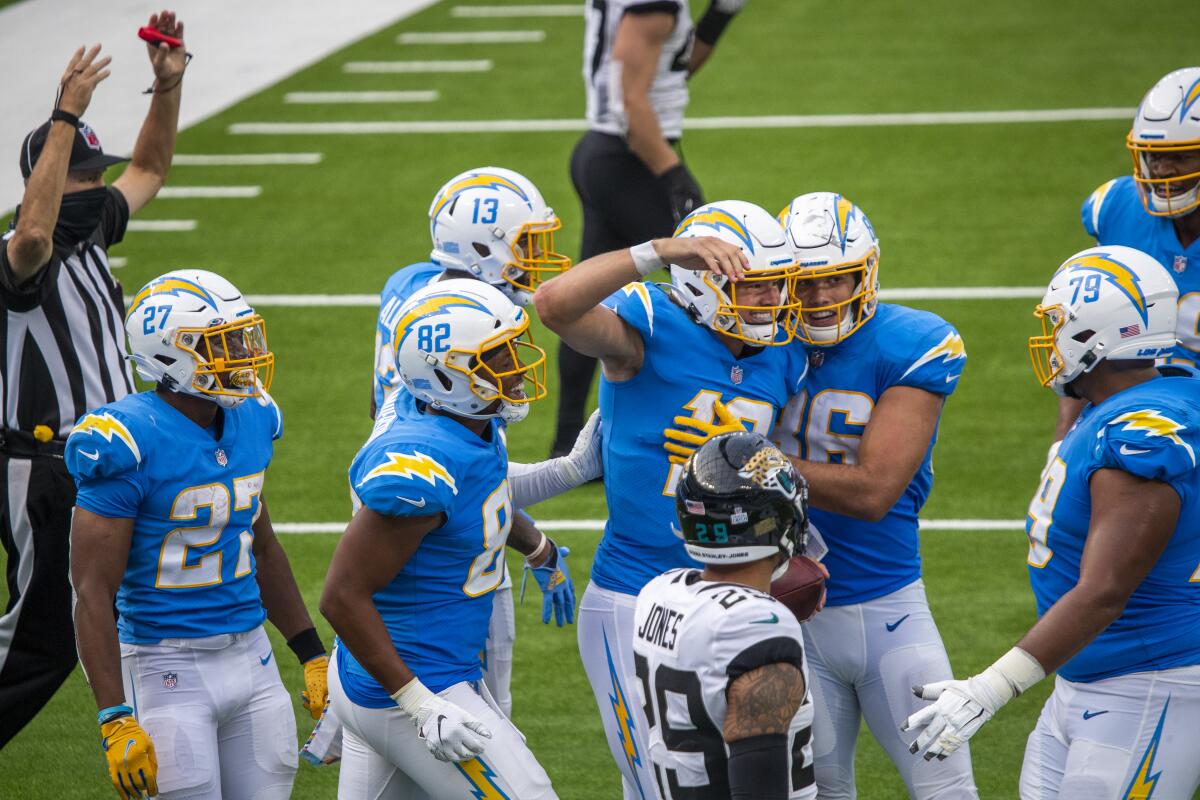 Chargers quarterback Justin Herbert, center, celebrates with teammates after scoring on a touchdown run.