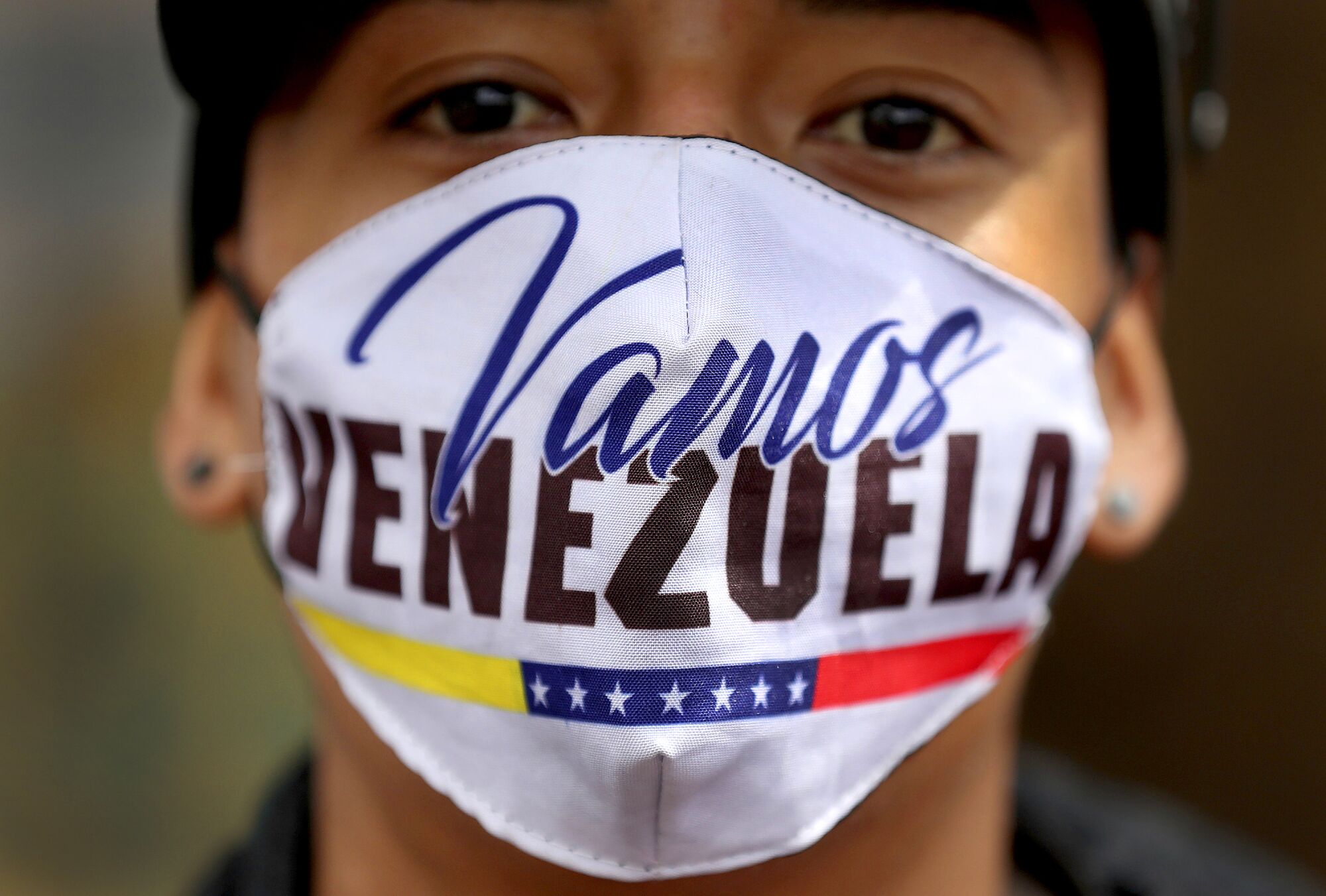 COLOMBIA: A Venezuelan migrant wears a mask that reads "Let's go Venezuela" in Spanish as he walks toward the Venezuelan border from Bogota. The Colombian government ordered a lockdown in an effort to prevent the spread of the coronavirus.