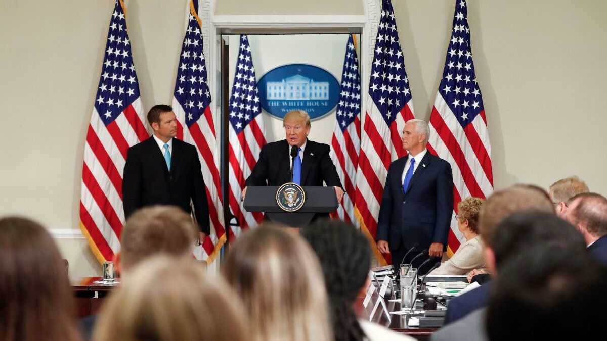 President Trump, with Kansas Secretary of State Kris Kobach, left, and Vice President Mike Pence, speaks at a meeting of the Presidential Advisory Commission on Election Integrity on July 19 in Washington.