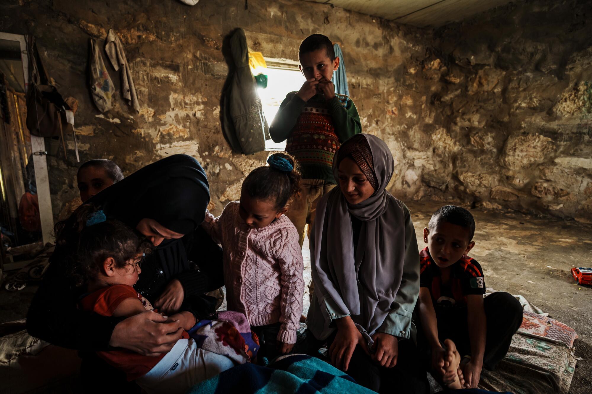 Iman Jabarin checks on her children as they stay at home with her, on close watch for Israeli settlers.