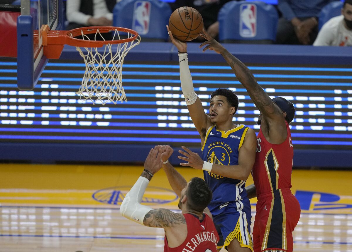 Golden State Warriors guard Jordan Poole (3) shoots against New Orleans Pelicans guard Eric Bledsoe, right, and center Willy Hernangomez, bottom, during the first half of an NBA basketball game on Friday, May 14, 2021, in San Francisco. (AP Photo/Tony Avelar)