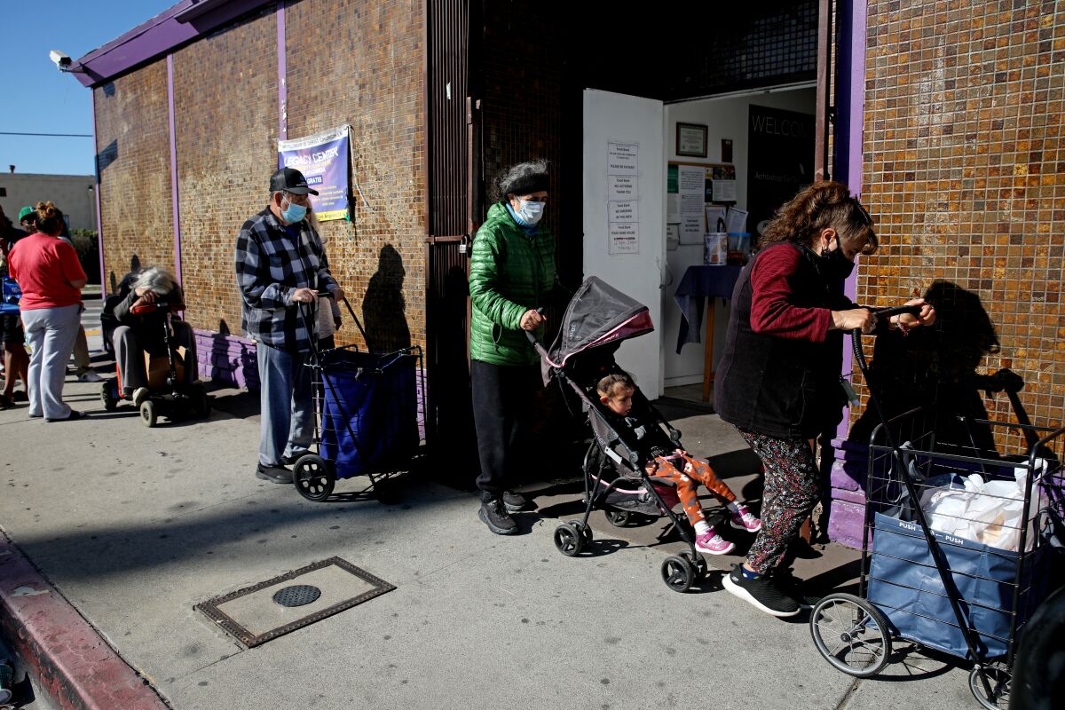 People wait in line outside a food bank at a church in Los Angeles on Tuesday.