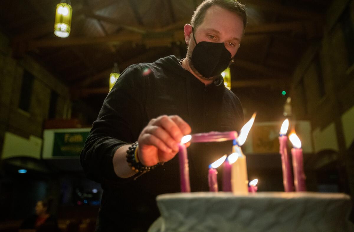 Pastor Ryan Chaddick lights a candle during Disability Day of Mourning  